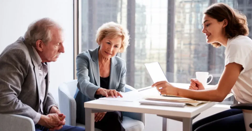 Senior couple reviewing immigration sponsorship requirements with an advisor