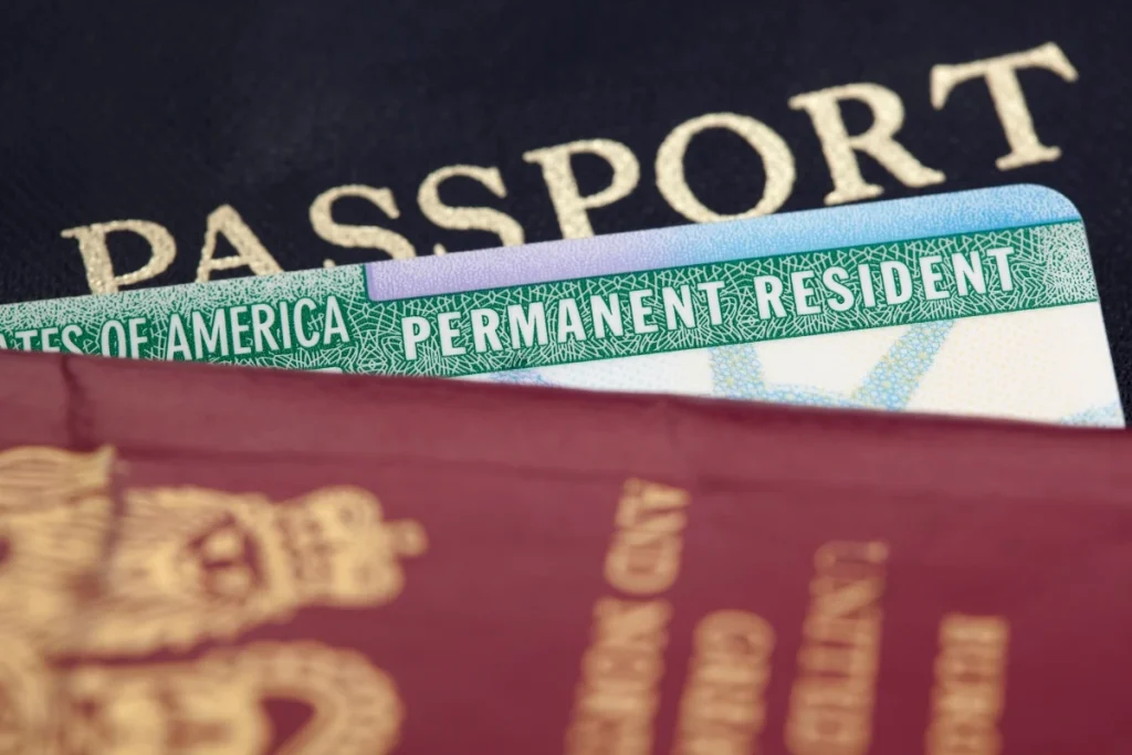 Permanent resident green card displayed with United States passport for immigration status